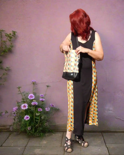 Langes Sommerkleid in schwarz/retro, mit Cutout am Bein, mit farblich passender Handtasche